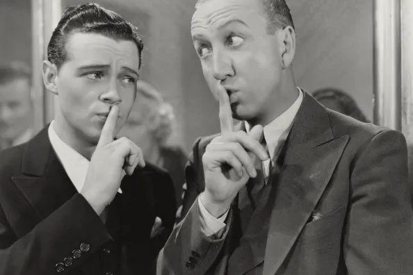 Illustration d'un club deal - Deux hommes se regardent le doigt sur la bouche en signe de secret - Extrait vieux film noir et blanc